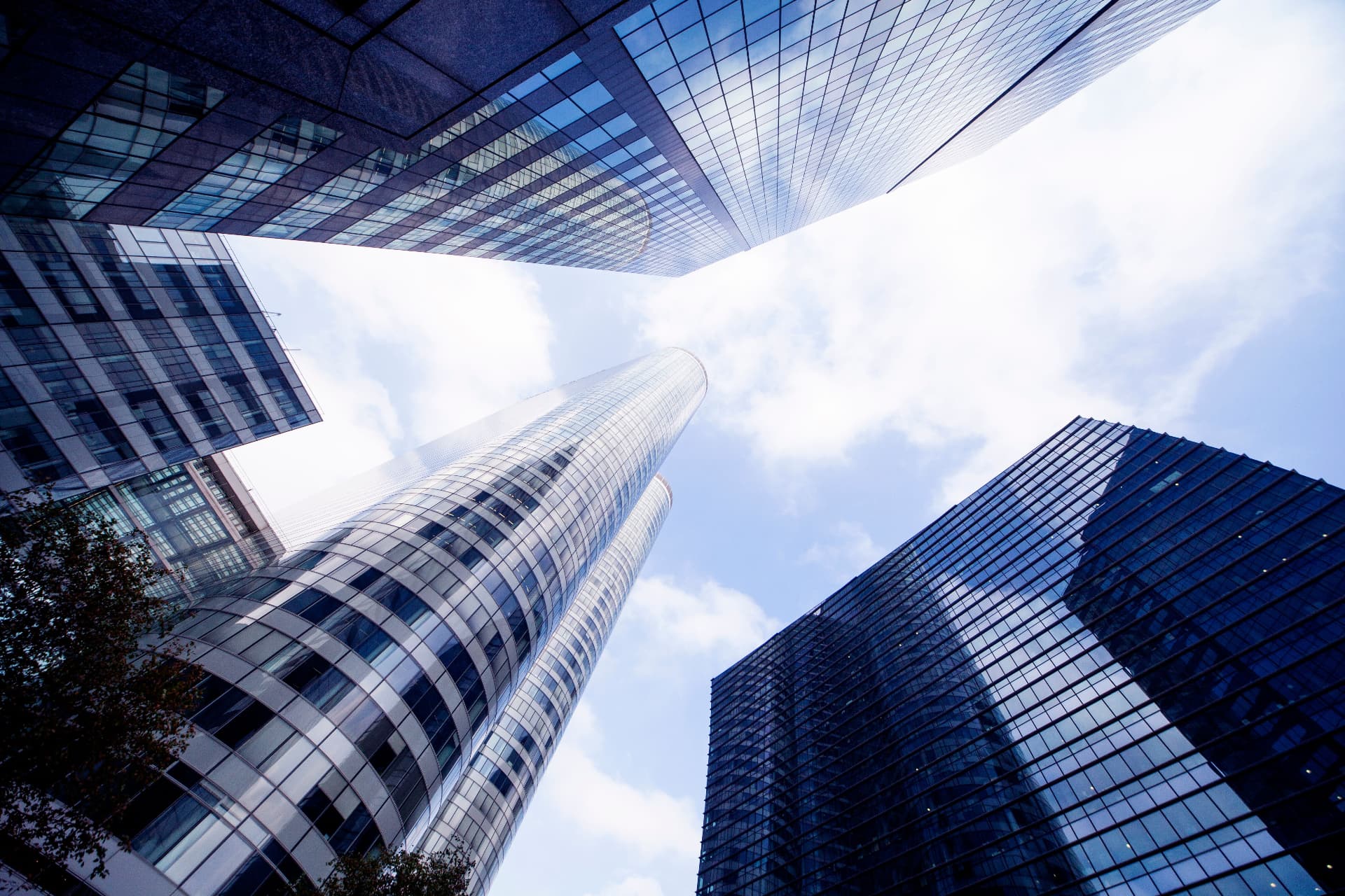 Office towers seen from street level against a bright sky