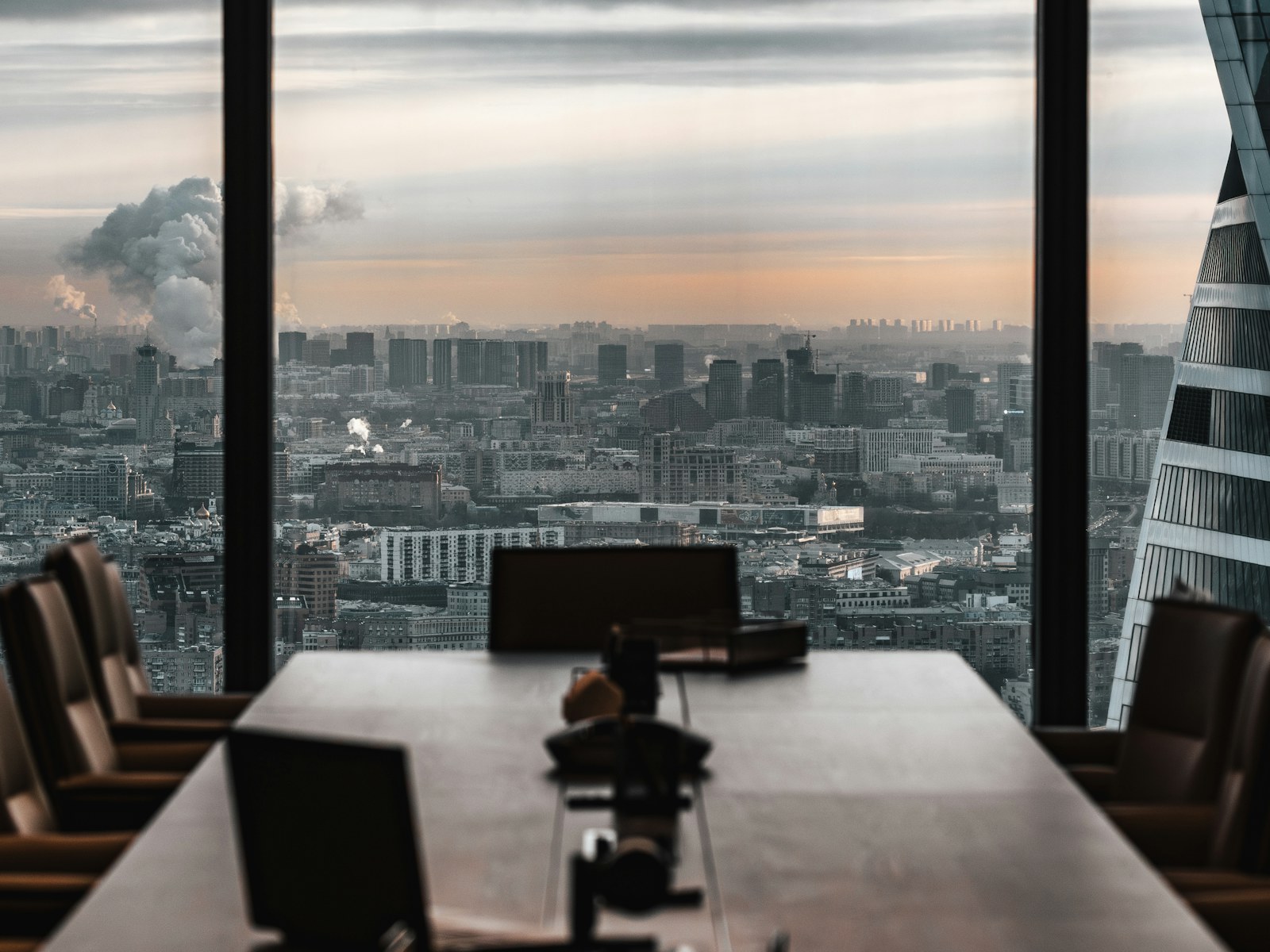 Empty boardroom with a panoramic city skyline at dusk